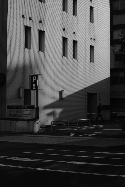 a person walking past a tall building on a street corner