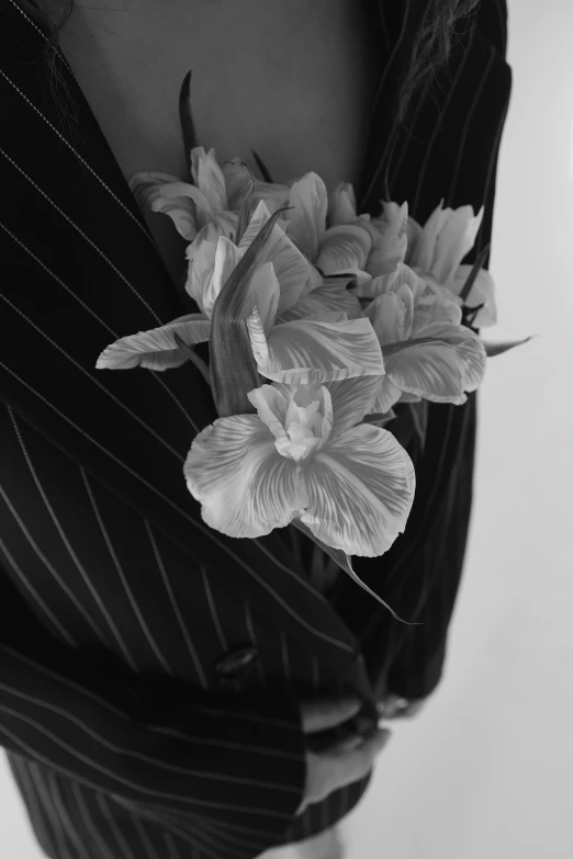 a person wearing a suit and holding a floral arrangement