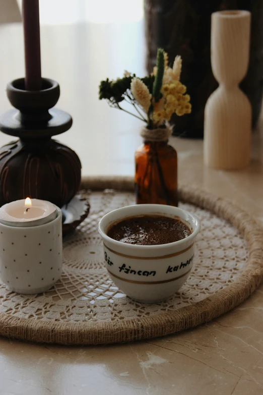 there is a candle and some coffee in a small bowl