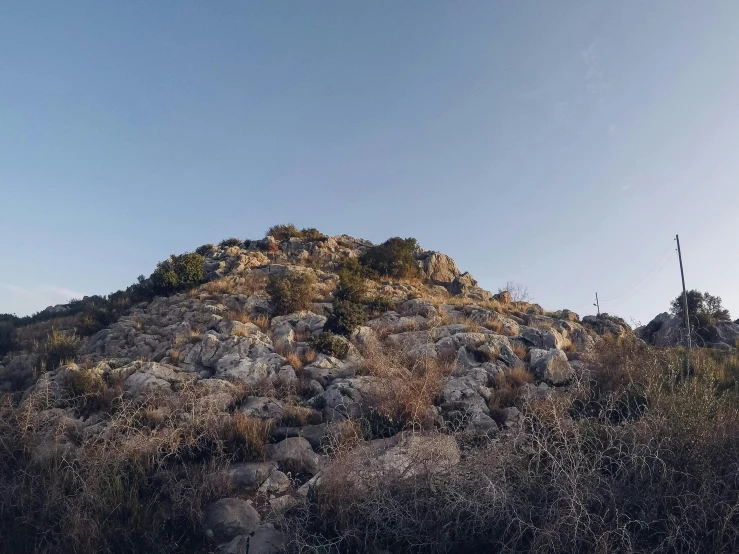 a large mountain with rocks and shrubs