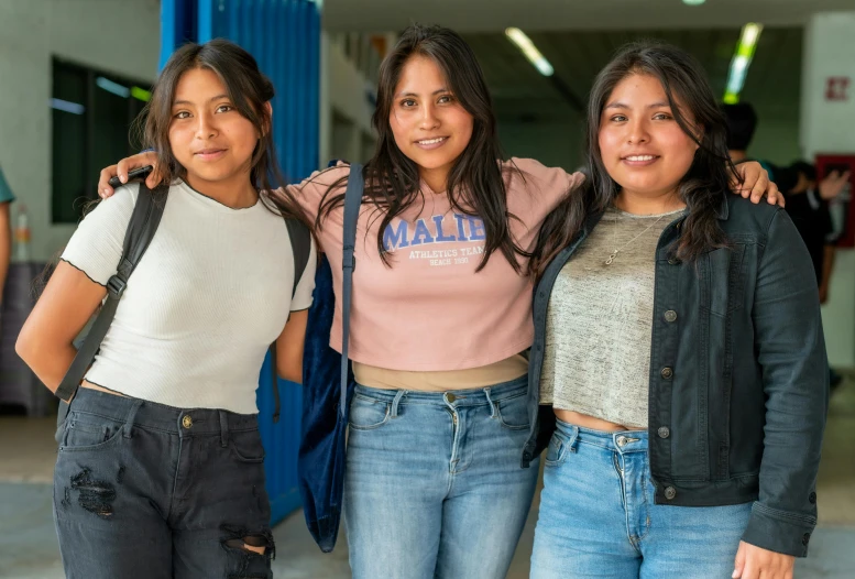 three women wearing jackets and smiling at the camera