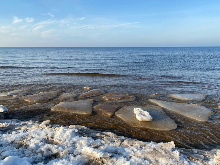 a sea view with low lying ice on the water and ice on land