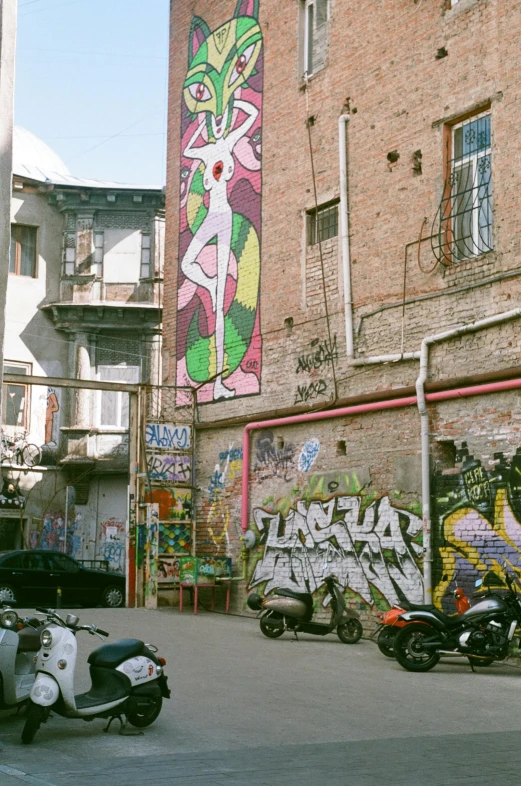 motorcycle parked on city street with graffiti on building