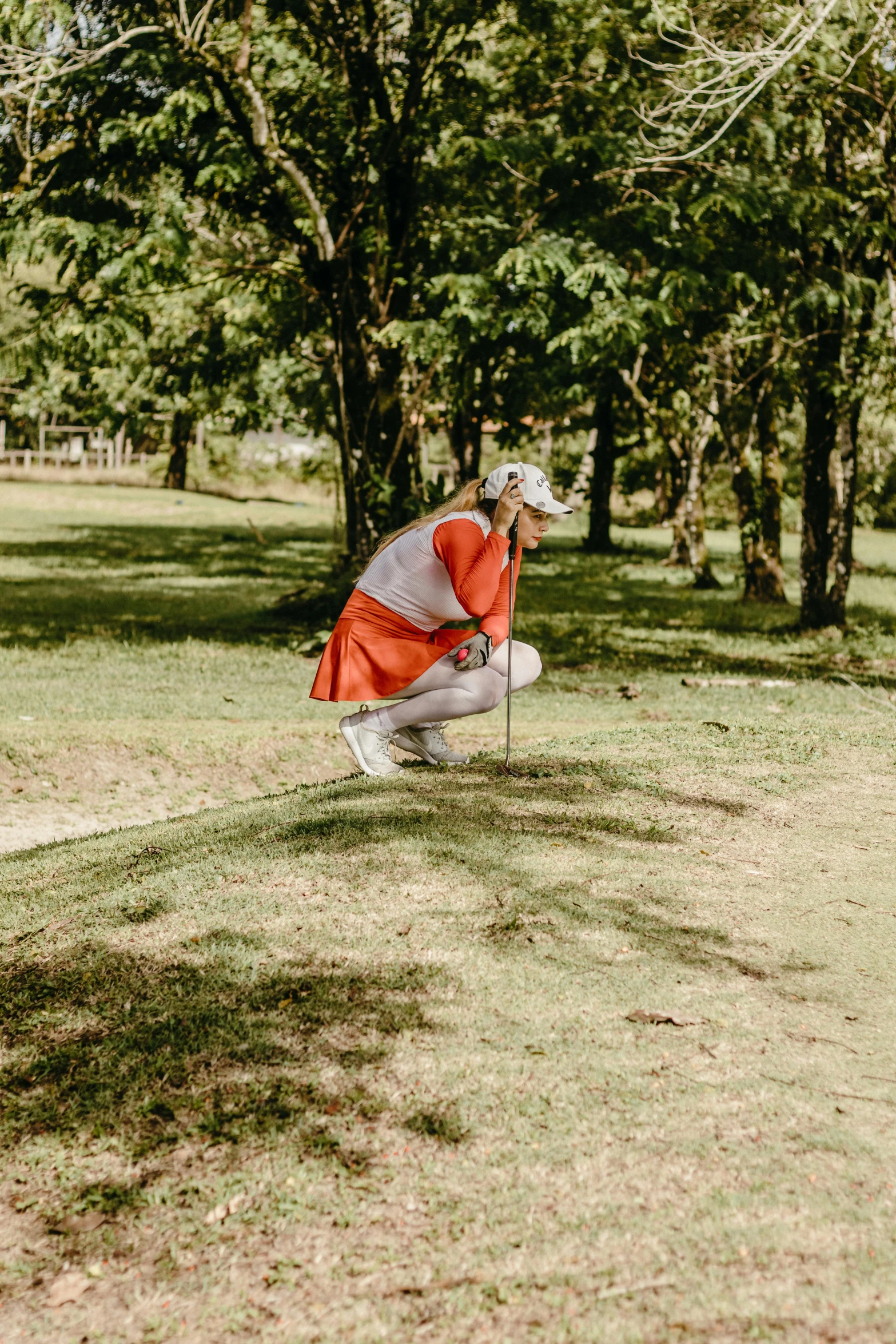 a woman kneeling on the ground in a park