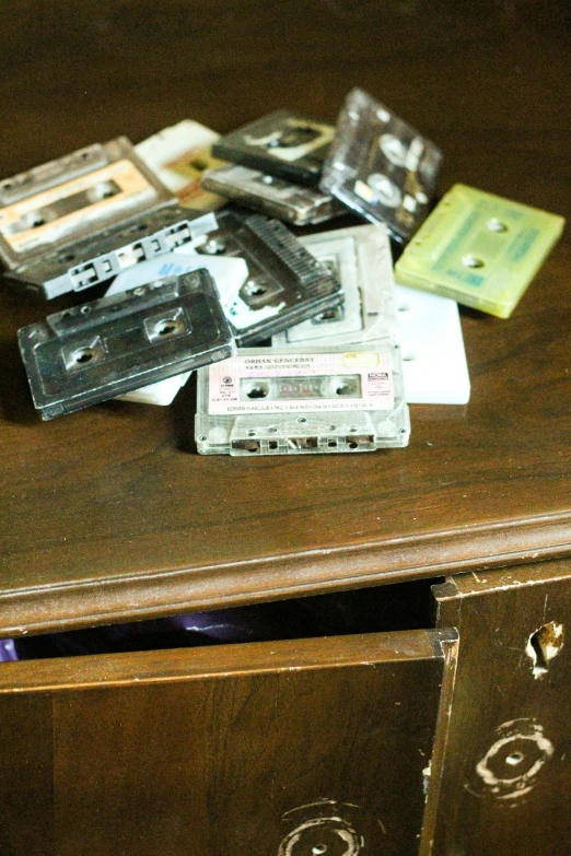 a table topped with cassettes and a drawer filled with other old fashioned tapes