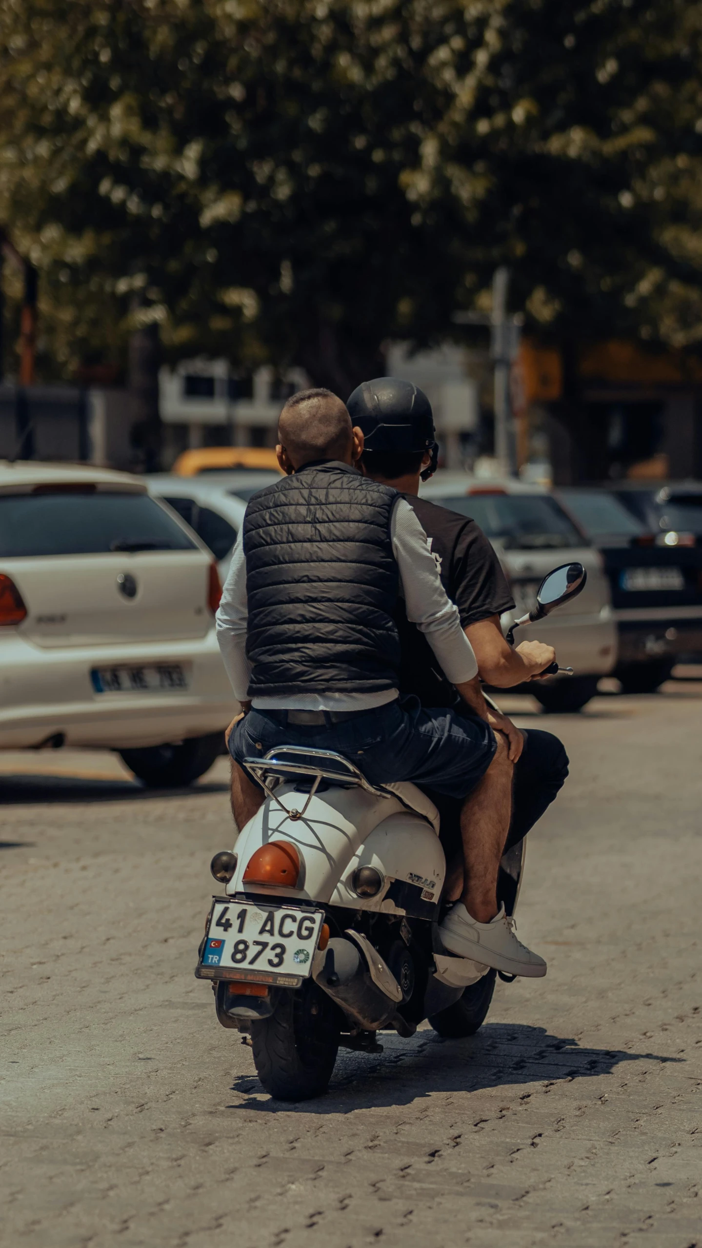 there are two men riding a motor scooter