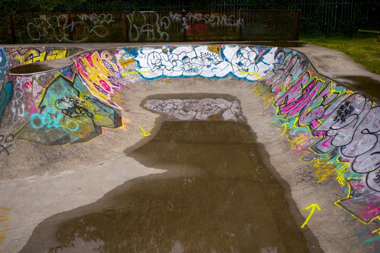 an empty skateboard park has graffiti written all over it