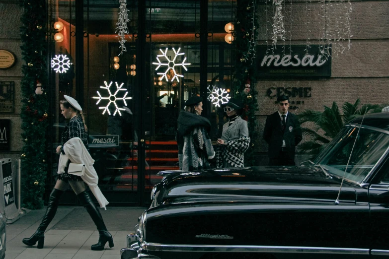 a woman walking by a car outside of a building