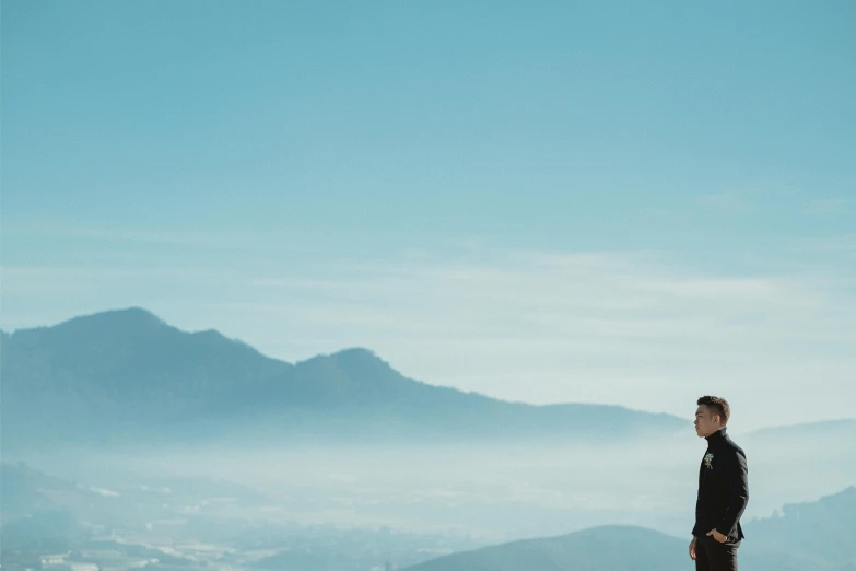 man looking up at the mountains while standing alone