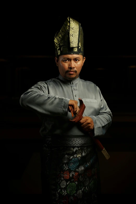 a man in an oriental dress is holding a knife