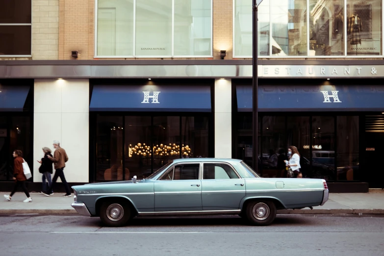 an old car parked in front of the h department store