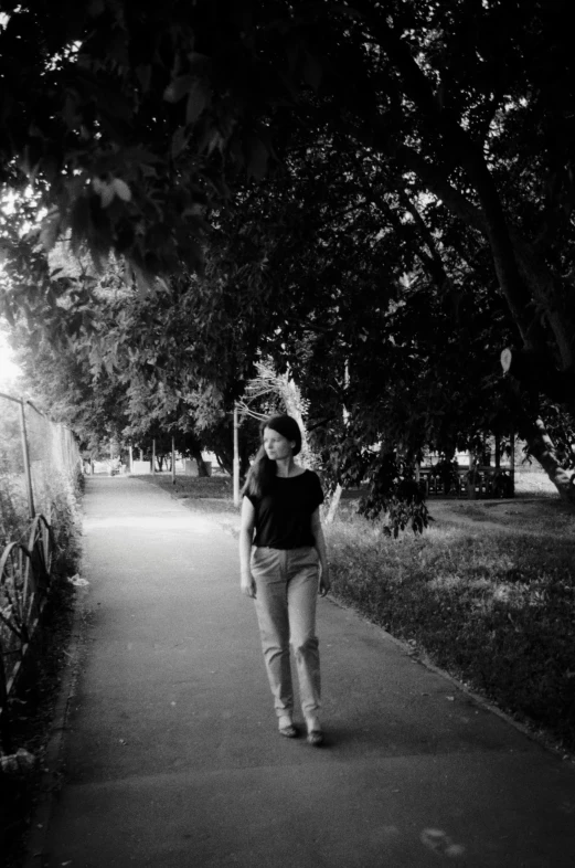 black and white pograph of woman walking down a sidewalk