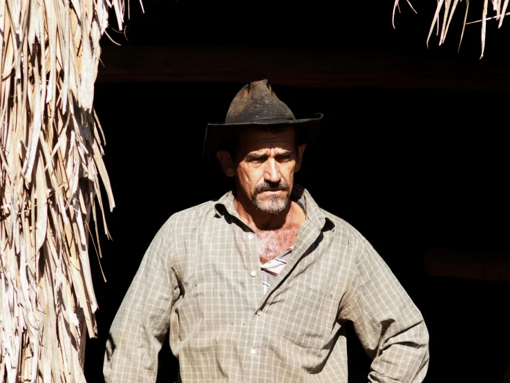 a man in a straw hut with his hands on his hips