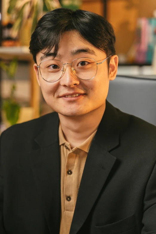 man with glasses sitting and smiling for the camera