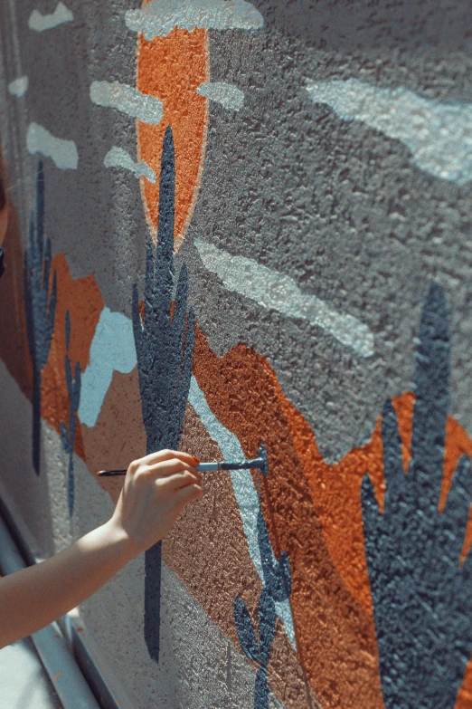 a person on a phone with their fingers on a wall painting