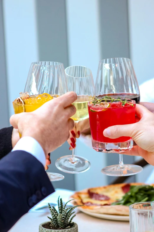 the men are holding wine glasses to toast