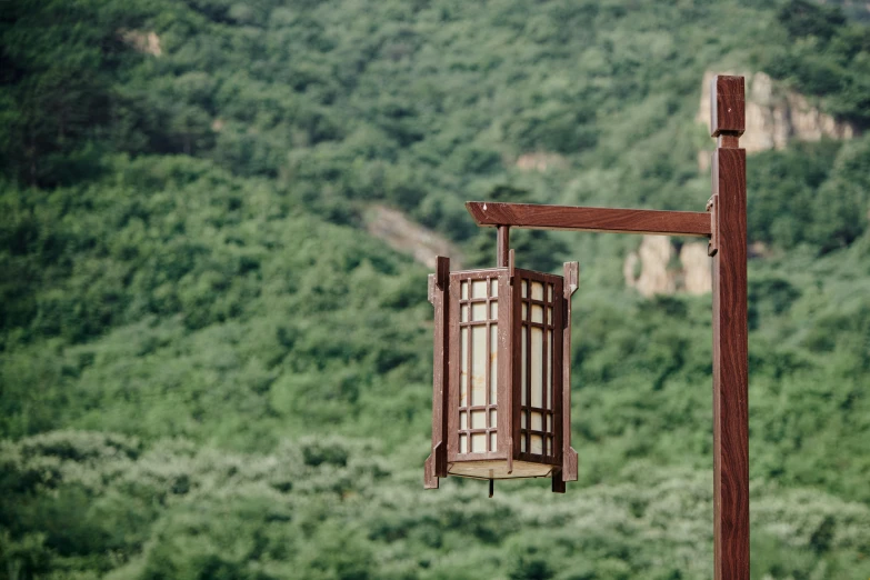 an old wooden bird feeder on top of a metal pole