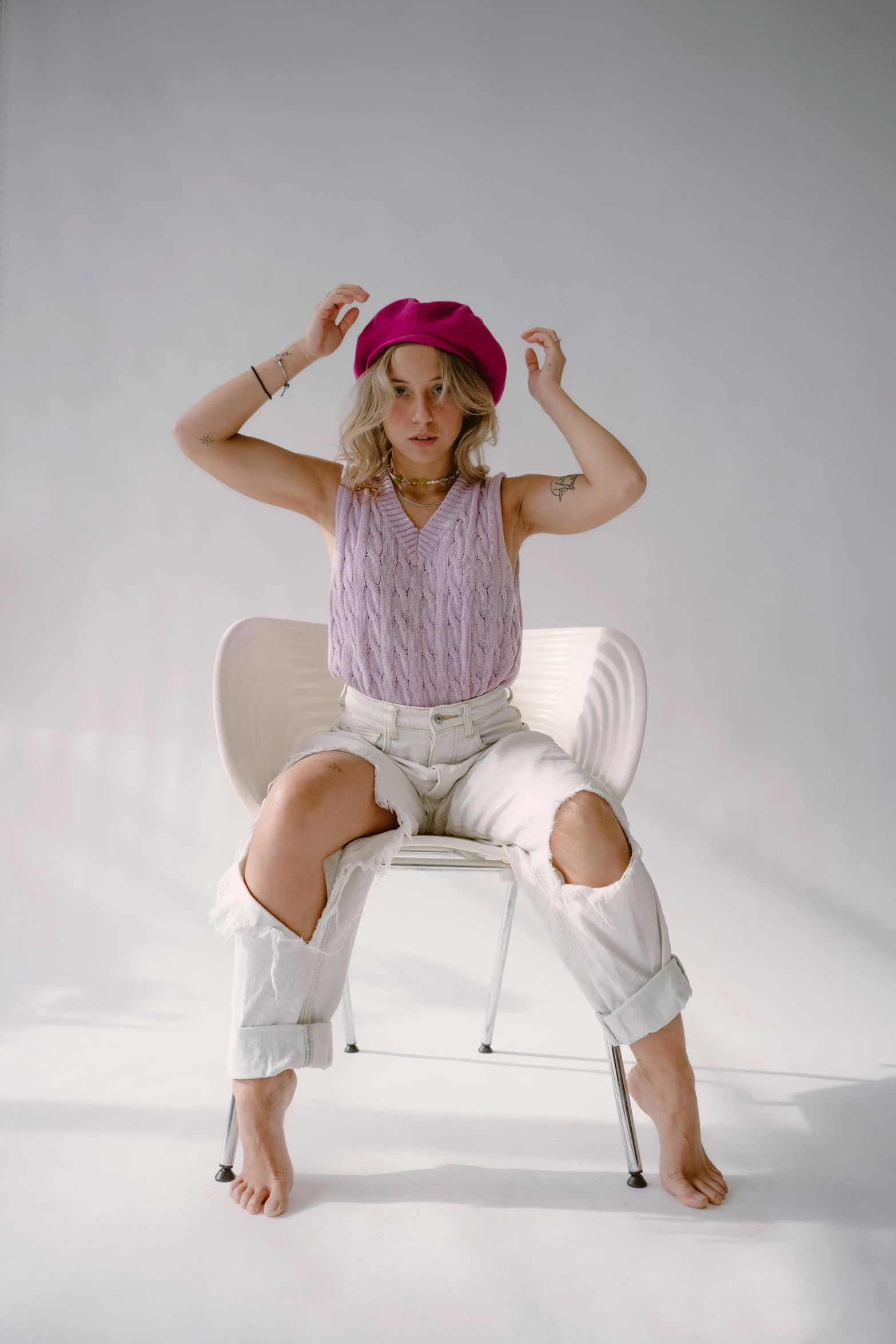 a woman in tight white pants and red hat sitting in a chair