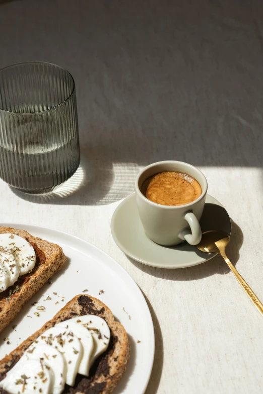 toasted breads and coffee on a table with water and a cup of beverage