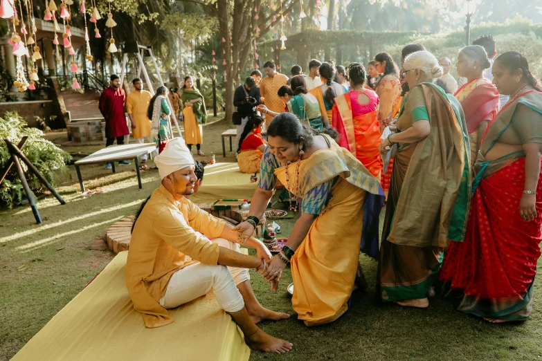 people are sitting on tables in sari attire