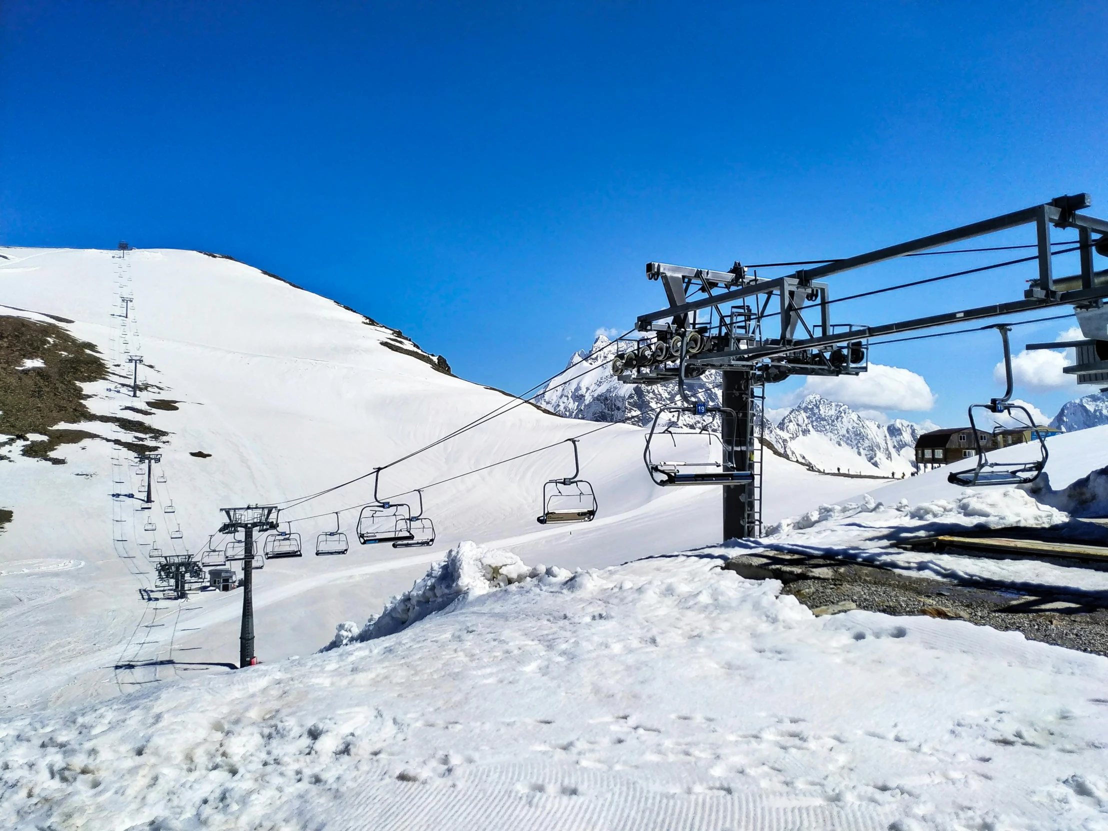 a ski lift is on a mountain side covered with snow