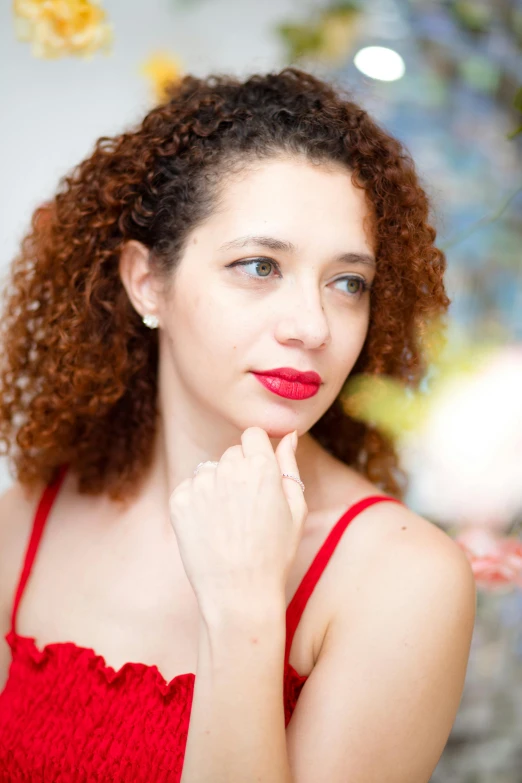 a young woman with curly hair and red lipstick