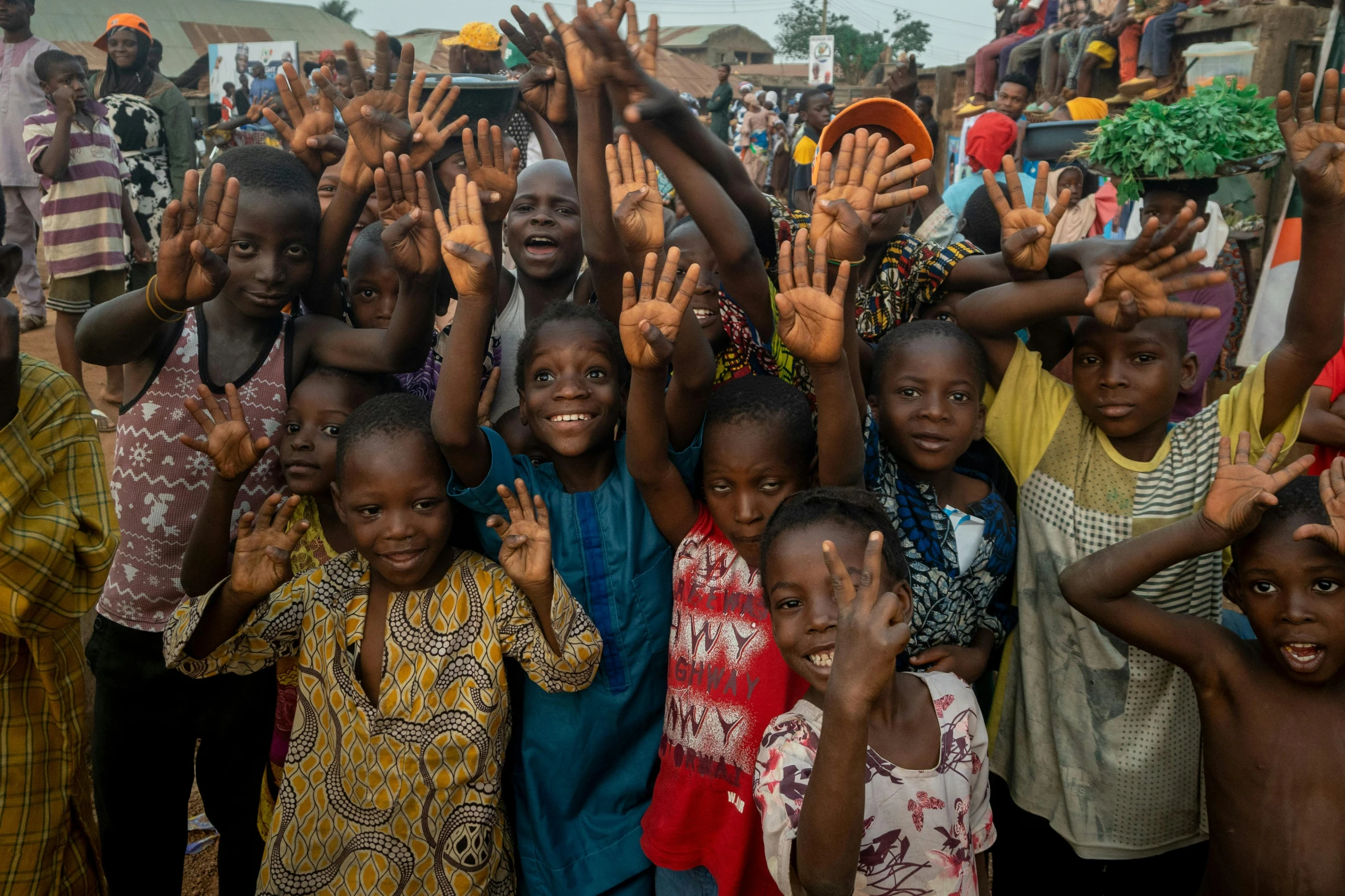 several children are standing together and waving