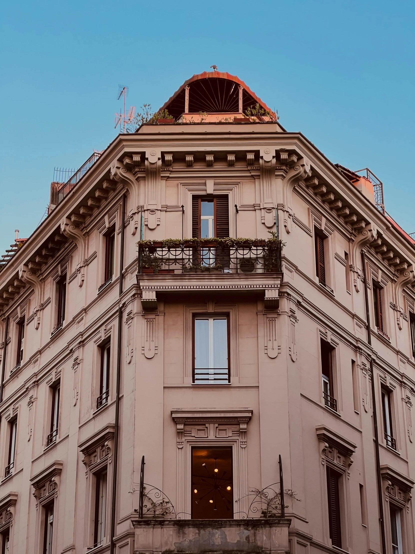 large beige building with ornate balconies and an arched top