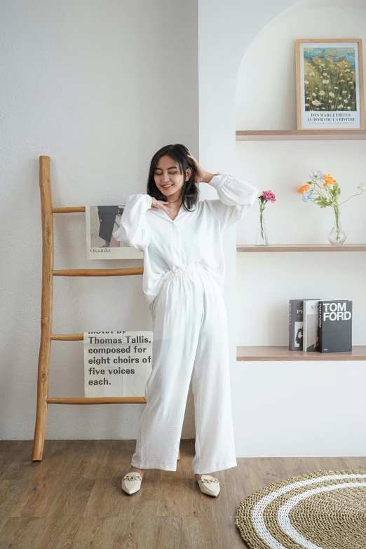 a woman stands in front of some shelves and poses for a po