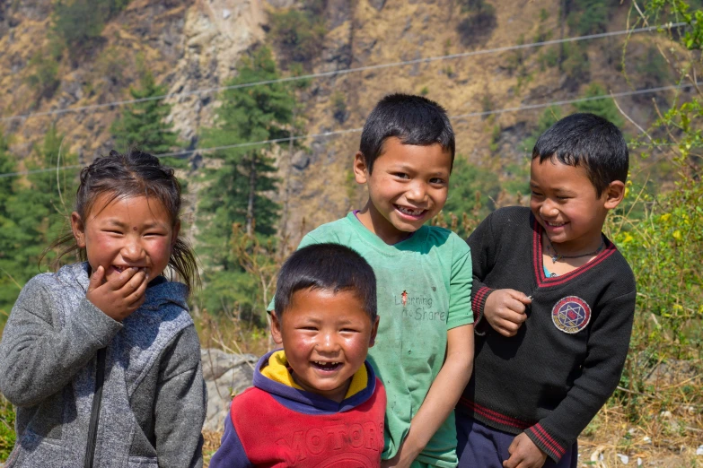 several young children standing in front of some mountains