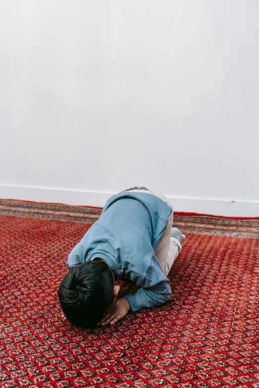 a young person sitting on the floor doing work