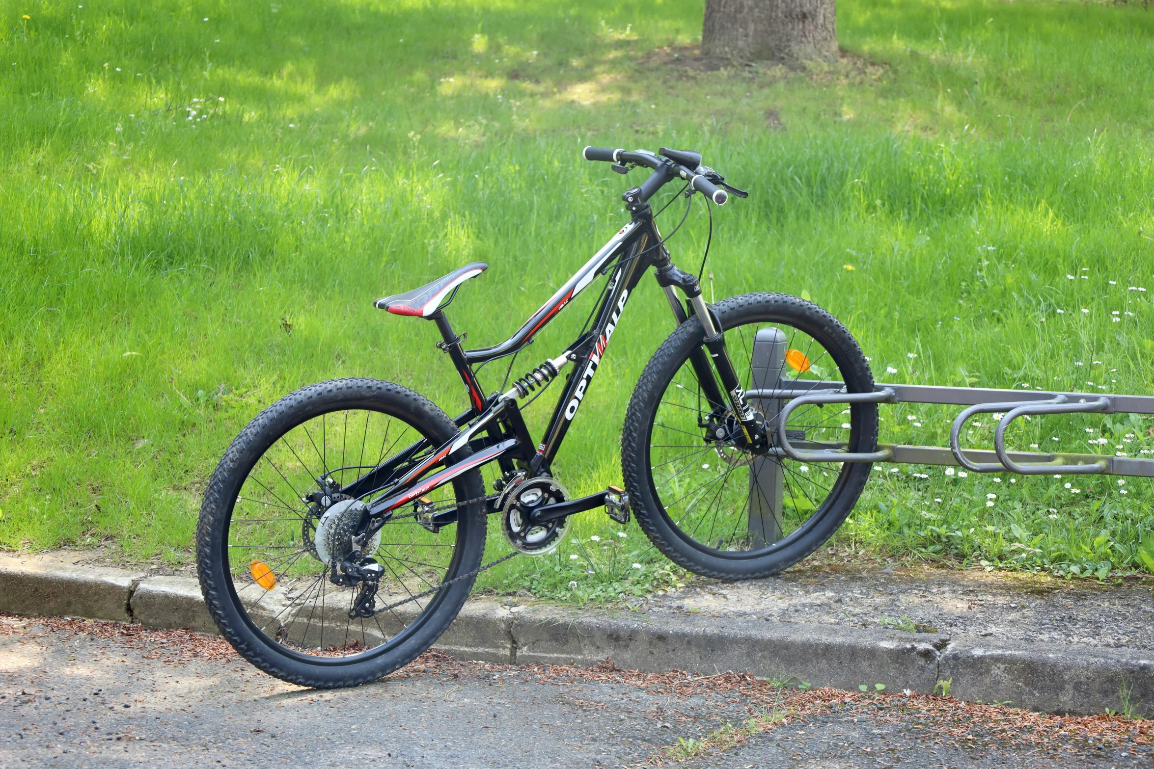 a bike leaned up on a fence in a park