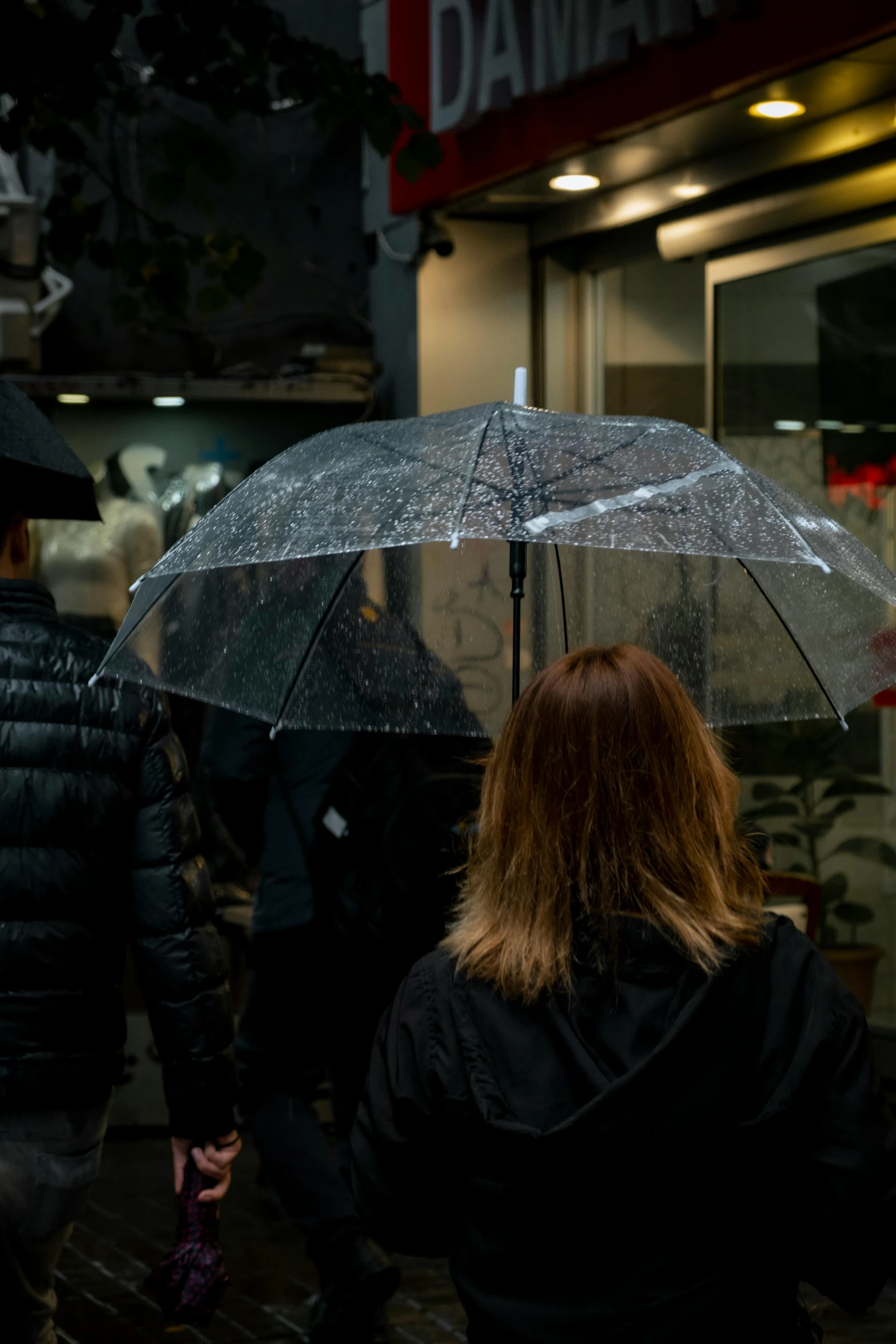 people are holding umbrellas walking down the street