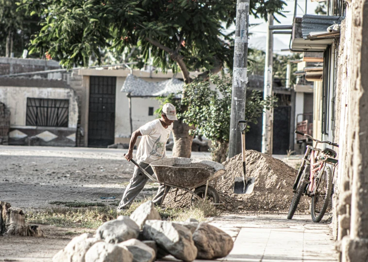 a person with a bike and a stone wheelbarrow