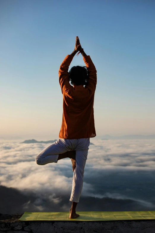 the person stands in a lotus position while doing yoga