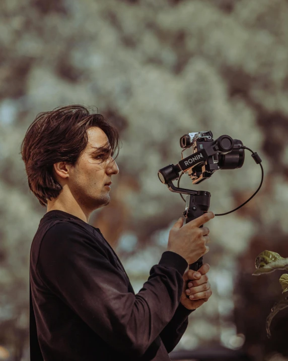 a man filming plants with a camera in a park