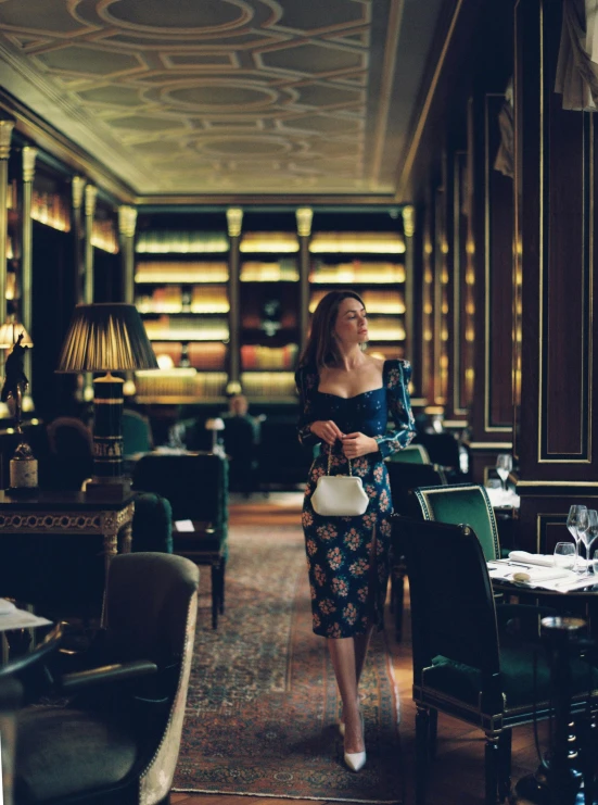 a woman standing in a room with tables and chairs