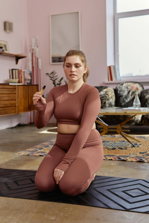 woman sitting on black mat in large room