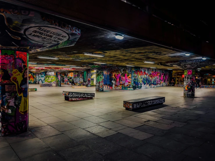 a group of skateboarders in a skate park with graffiti all over the walls