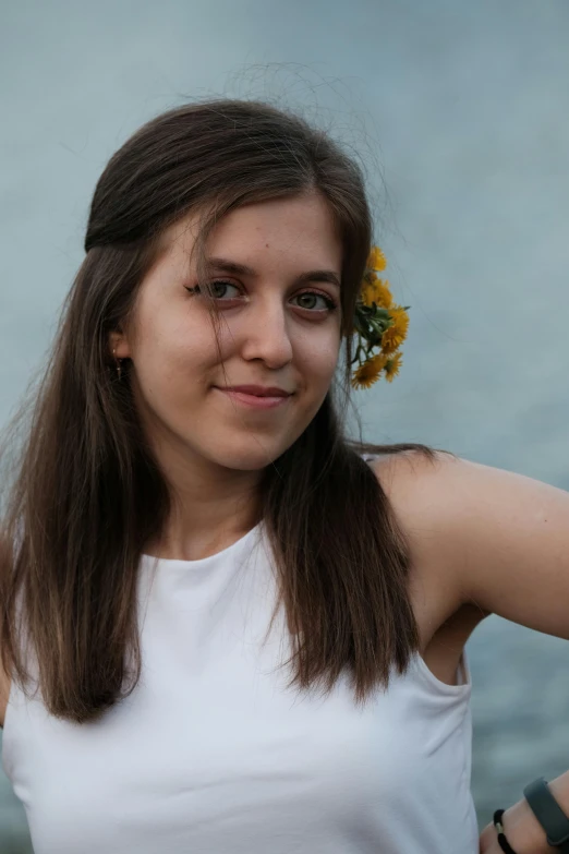 a woman is posing with a flower in her hair