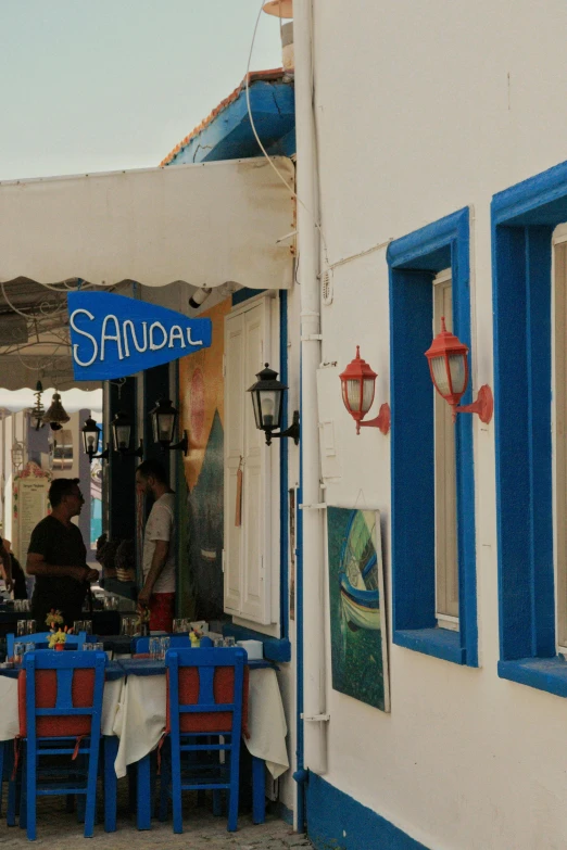 people at a blue and white restaurant eating out of blue chairs