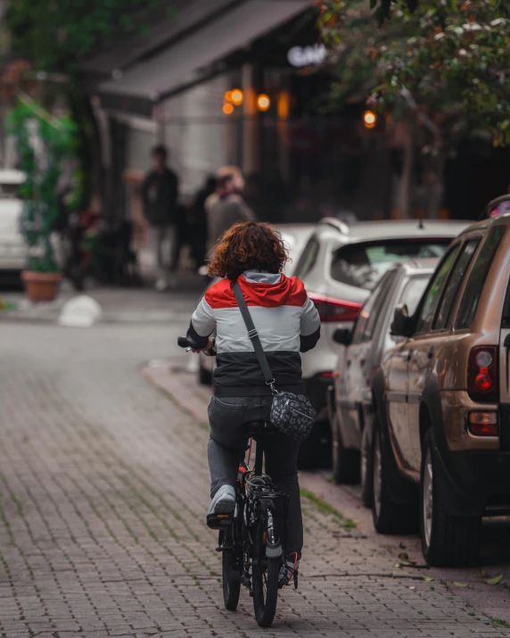 a person riding on the back of a bike down a street