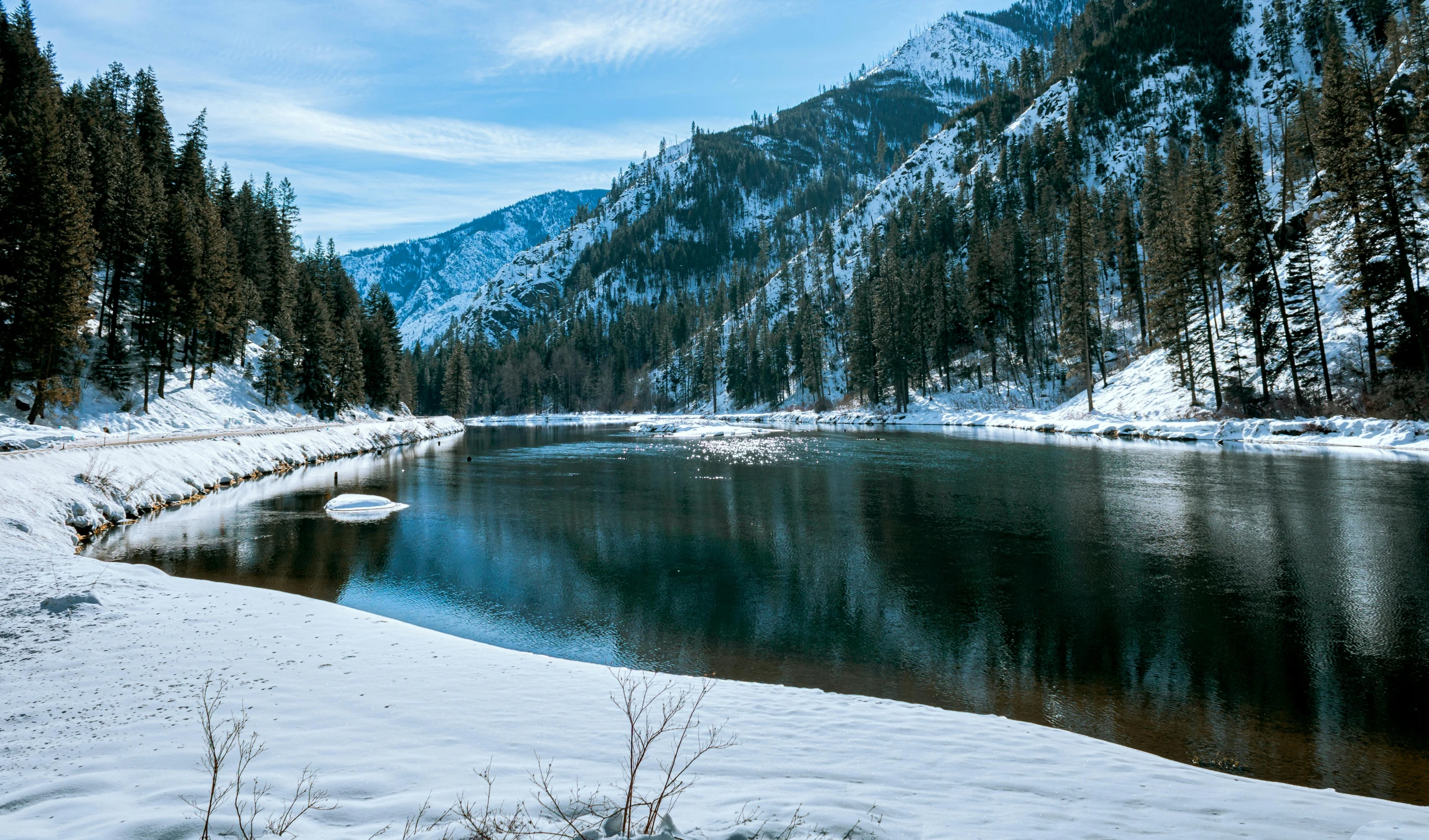 the snow covered ground is beside the river