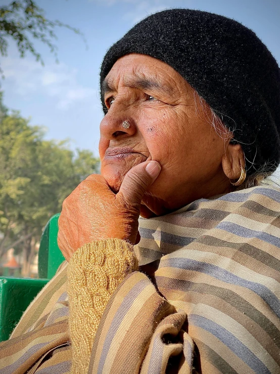 a woman is sitting outside on a bench