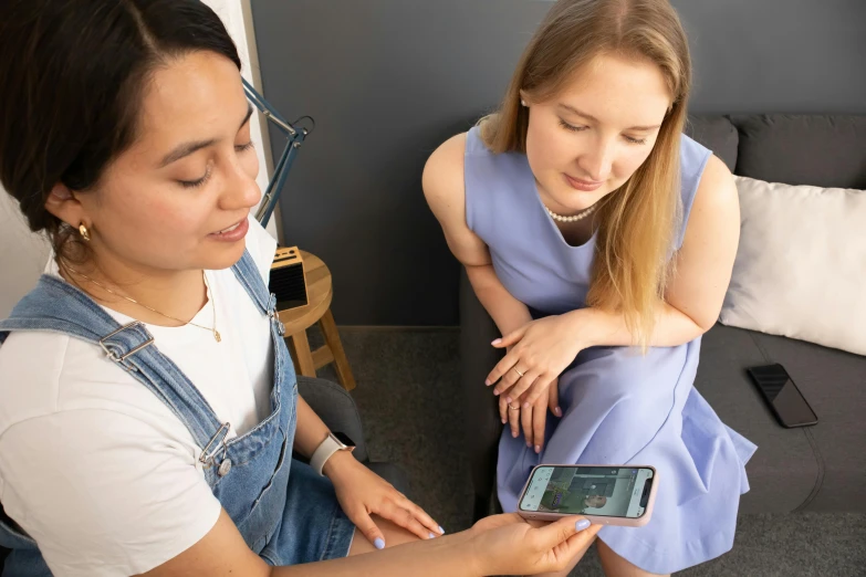 two girls looking at a mobile phone together