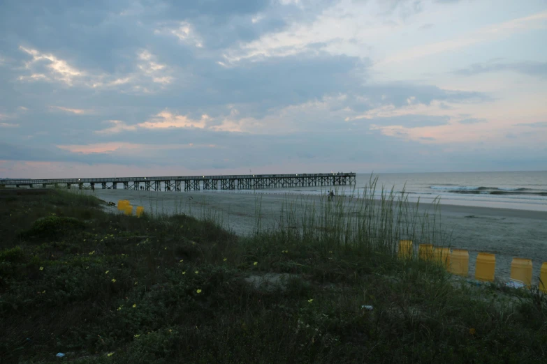 there is a pier and a beach on the ocean