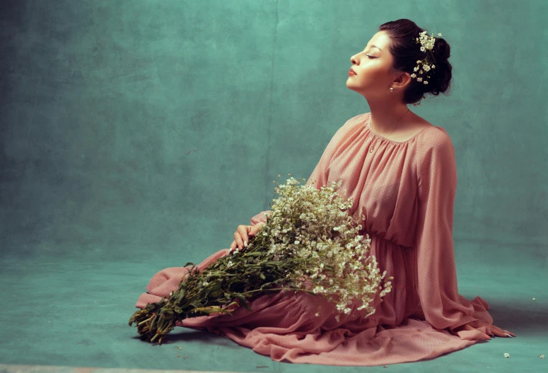 a woman with flower in her hair sitting cross legged