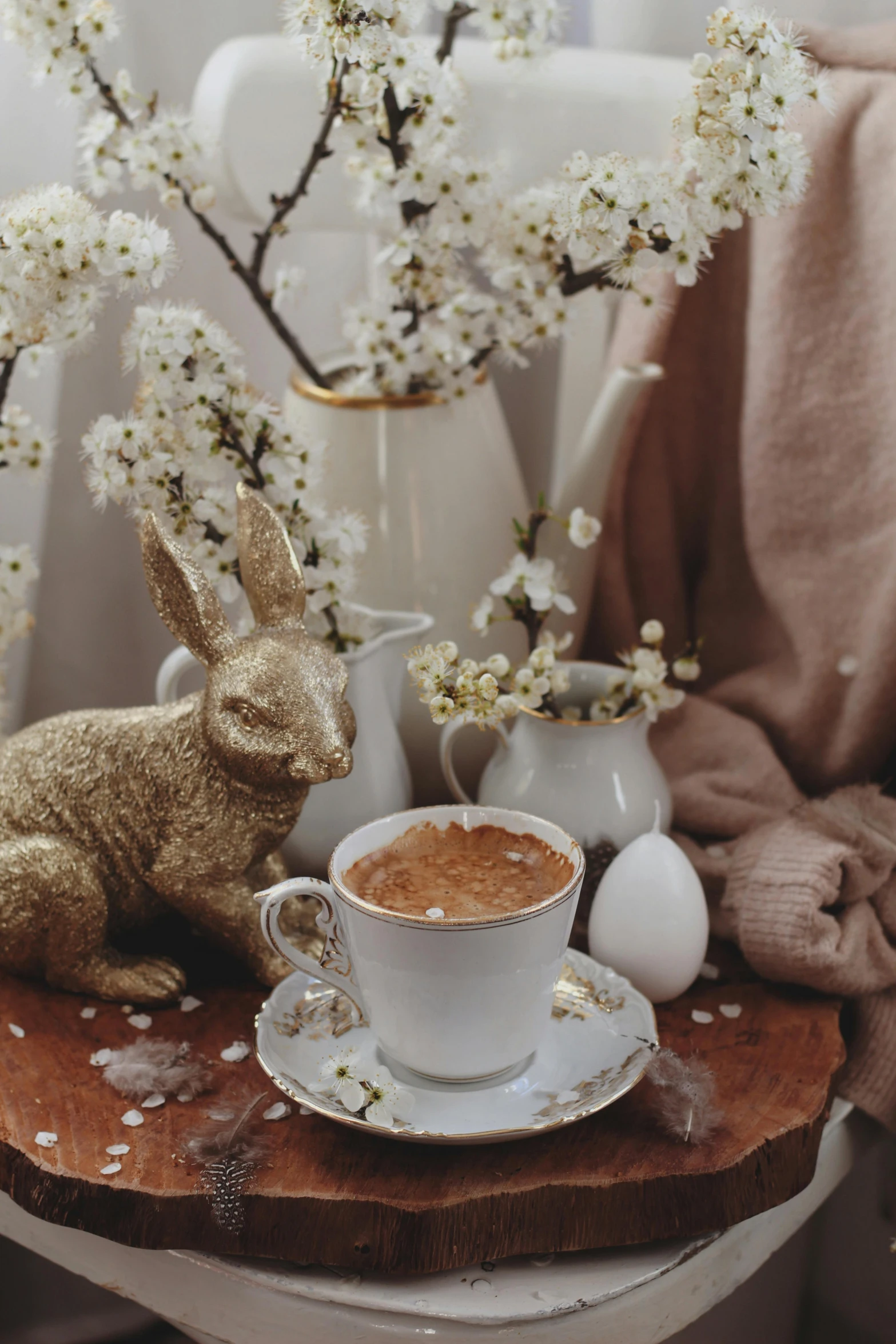 a brown bunny figurine next to a coffee cup on a plate