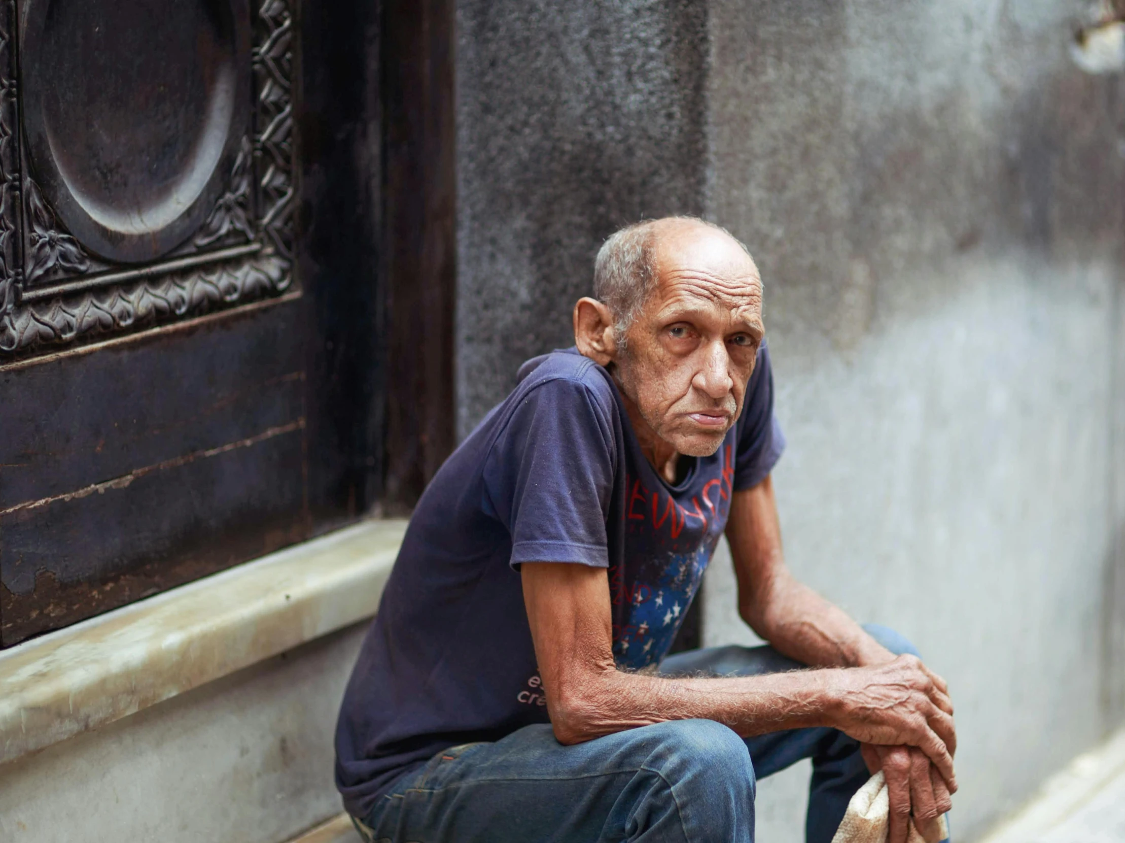 a man leaning on the side of a building