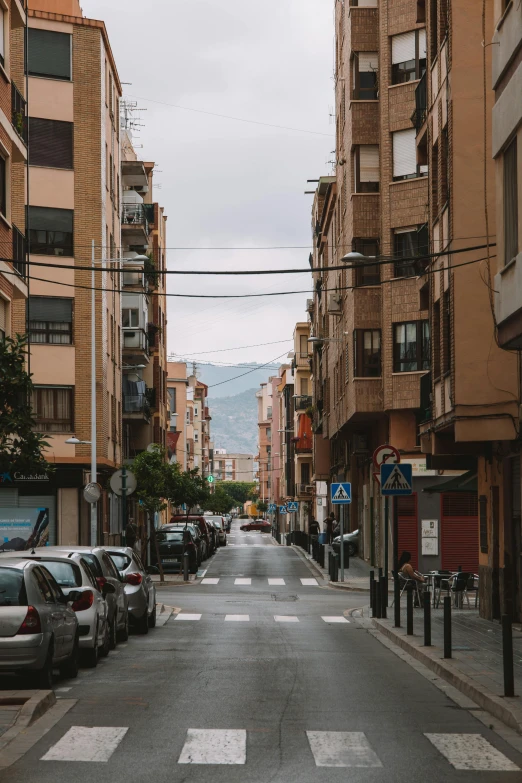 a long narrow street lined with tall brown buildings